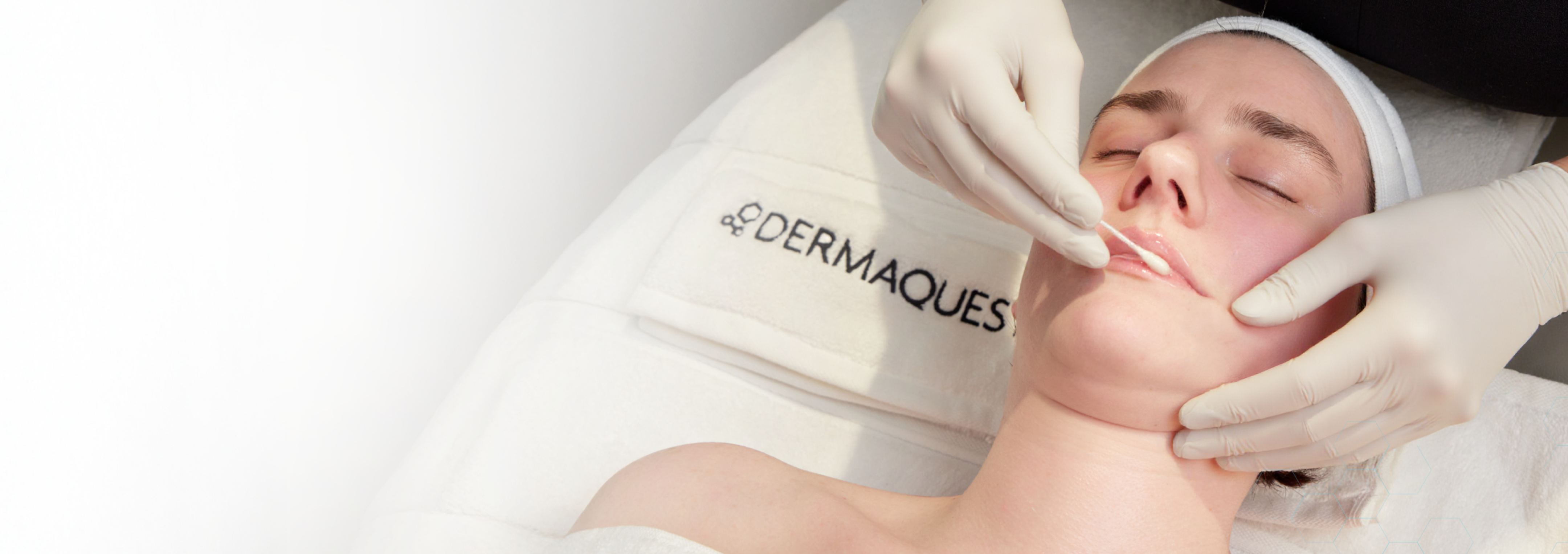 Person receiving a Dermaques facial treatment with gloved hands.