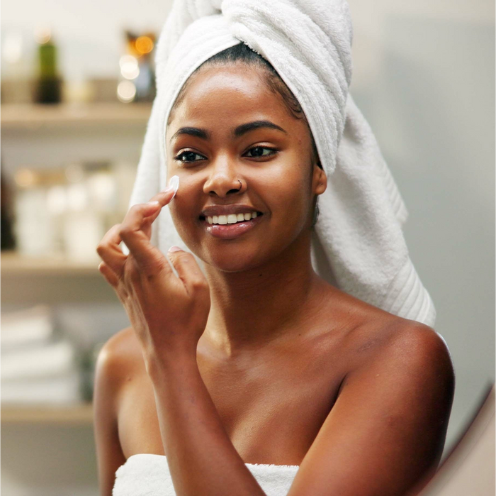 a woman applying cream on her face