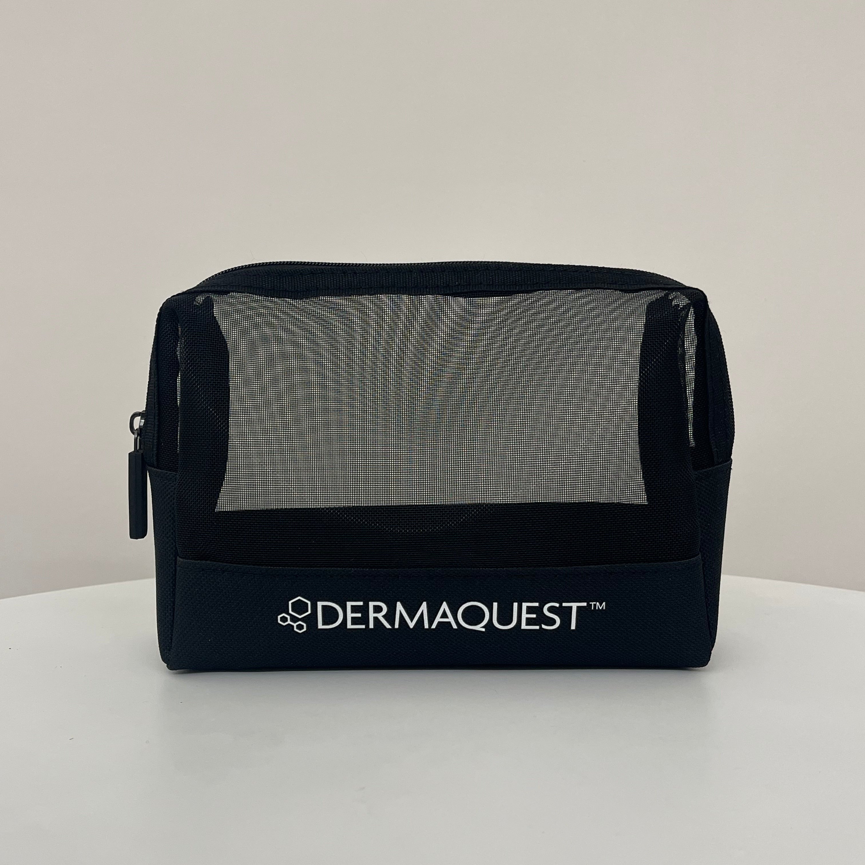 A black mesh zippered cosmetic bag with a white 'DERMAQUEST' logo printed on the front, sitting on a white surface against a light gray background.