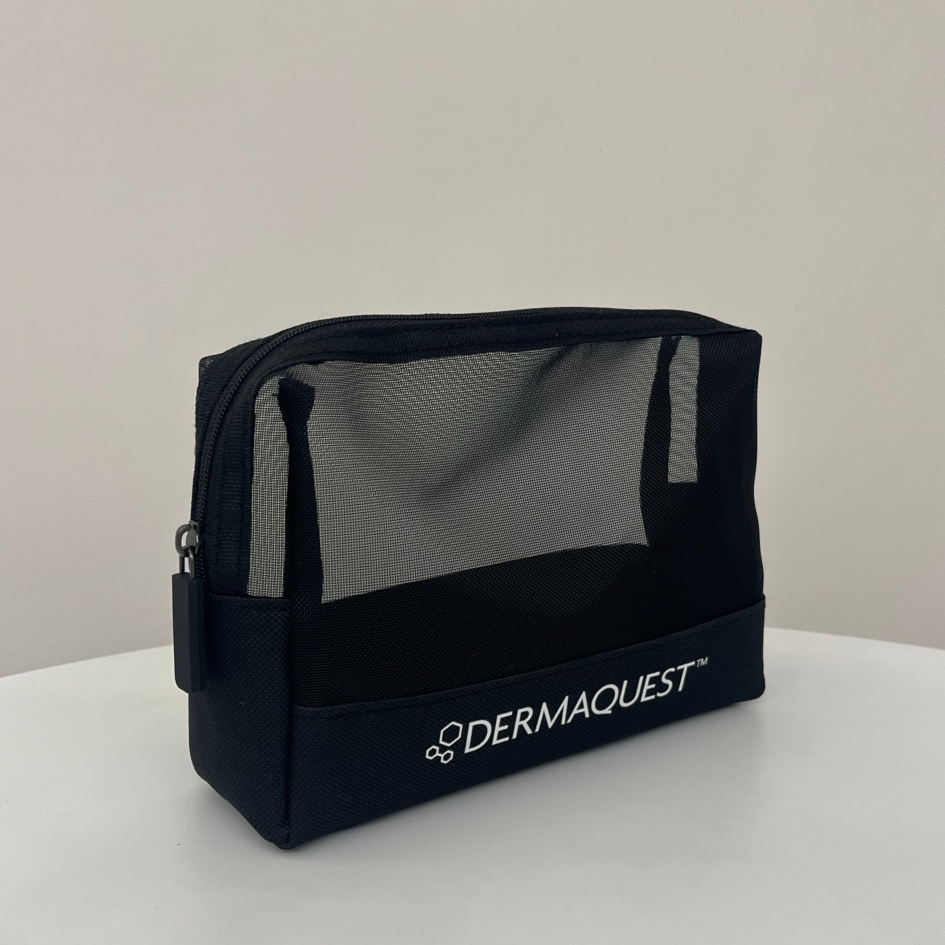 A black mesh and fabric cosmetic pouch with a white 'DERMAQUEST' logo on the front, sitting on a white surface against a light gray background.